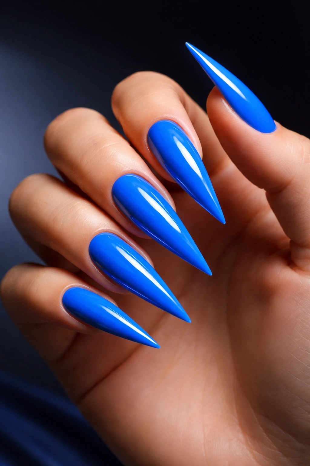 Close-up of electric blue stiletto nails with a high-gloss finish
