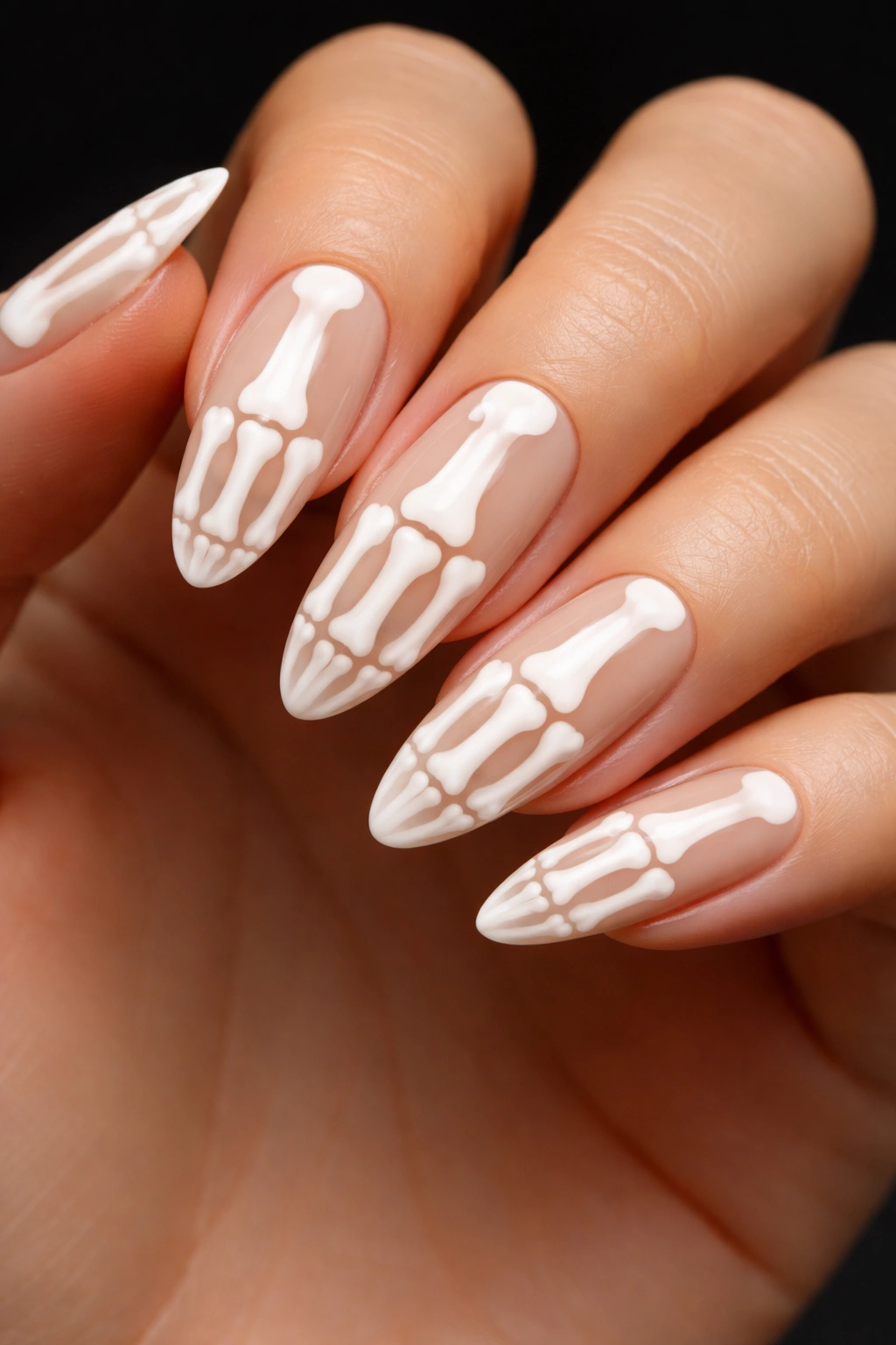 Close-up of skeleton hand nail art on nude base
