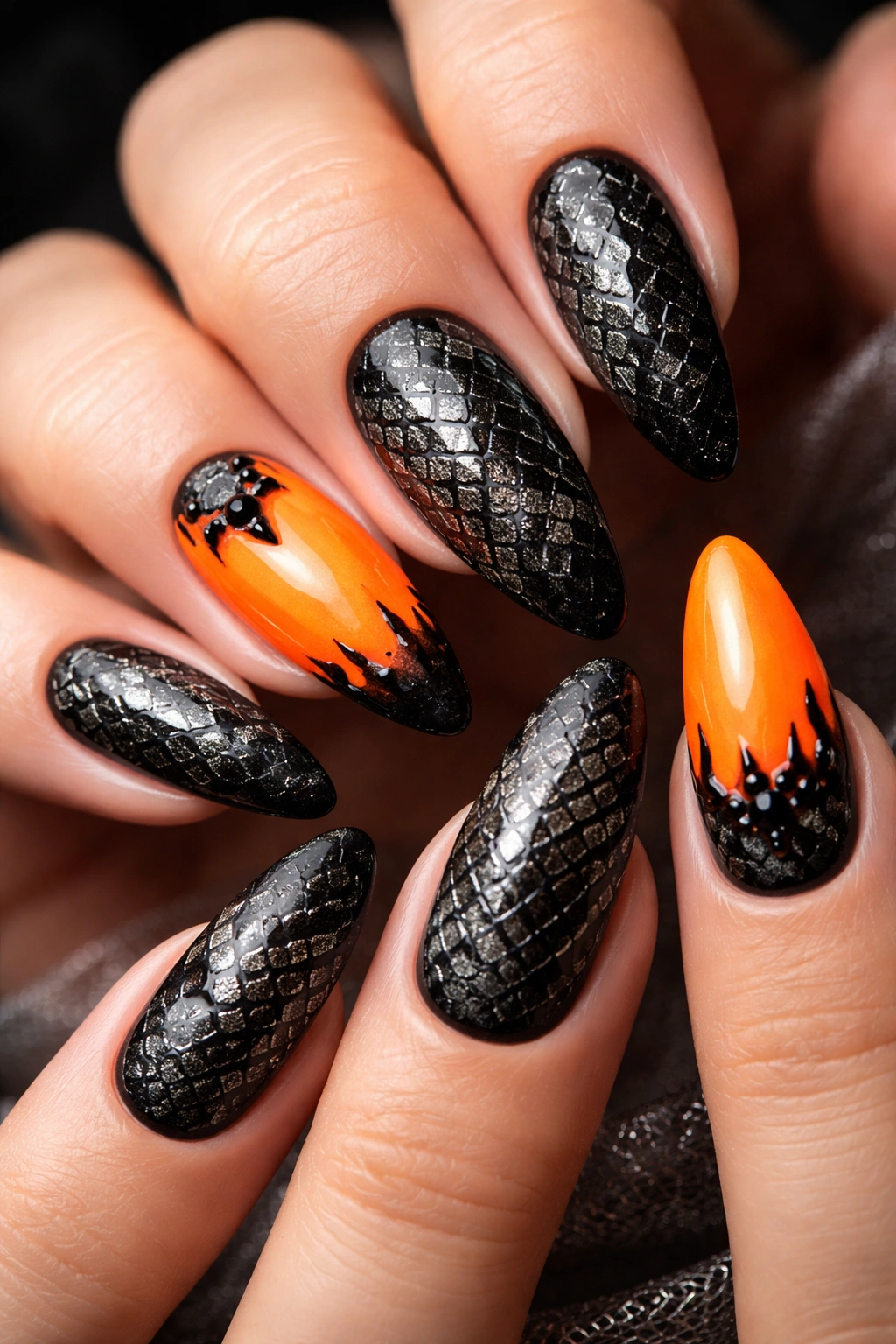 Close-up of snakeskin nail art with orange accents