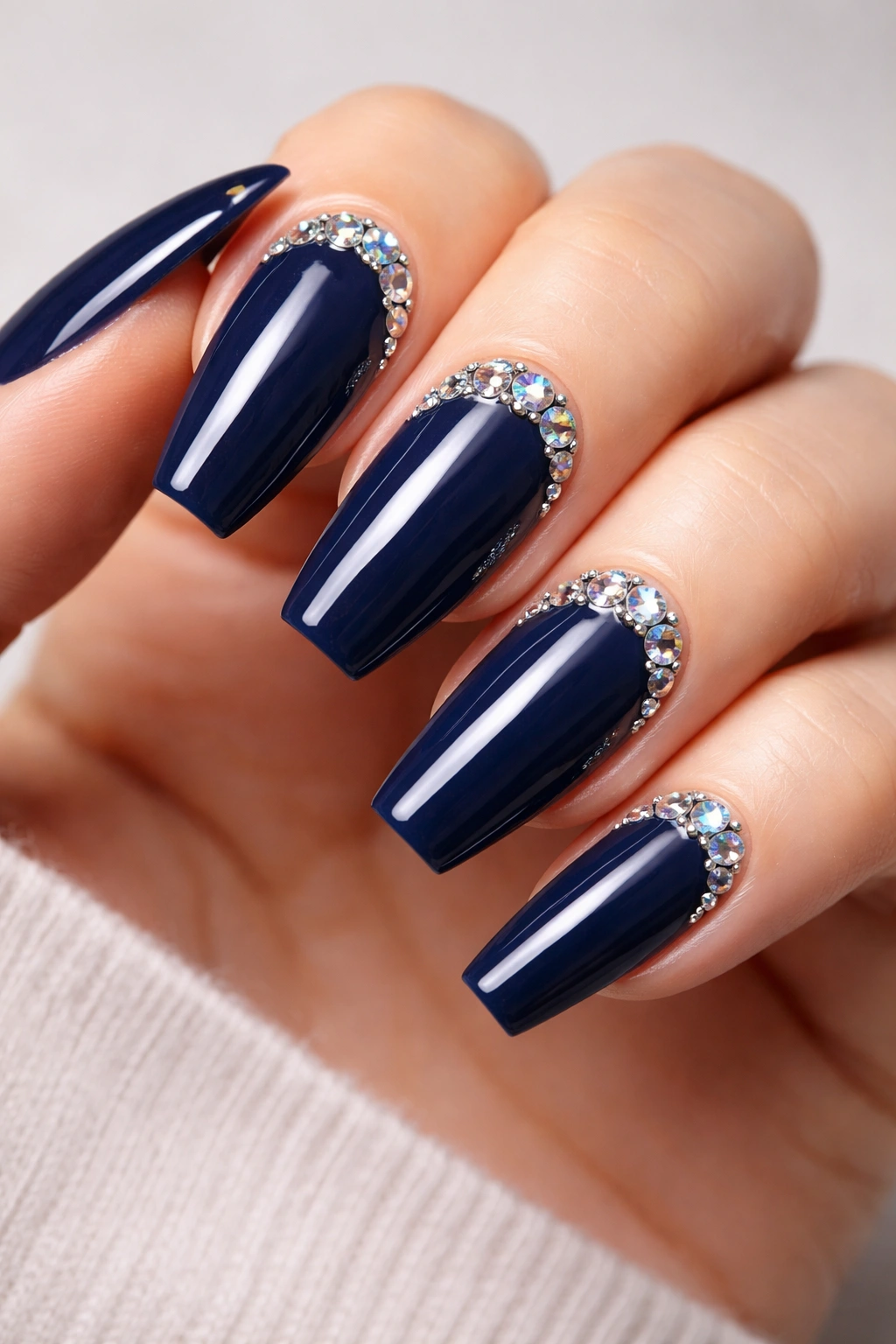 Close-up of navy blue nails with rhinestone accents