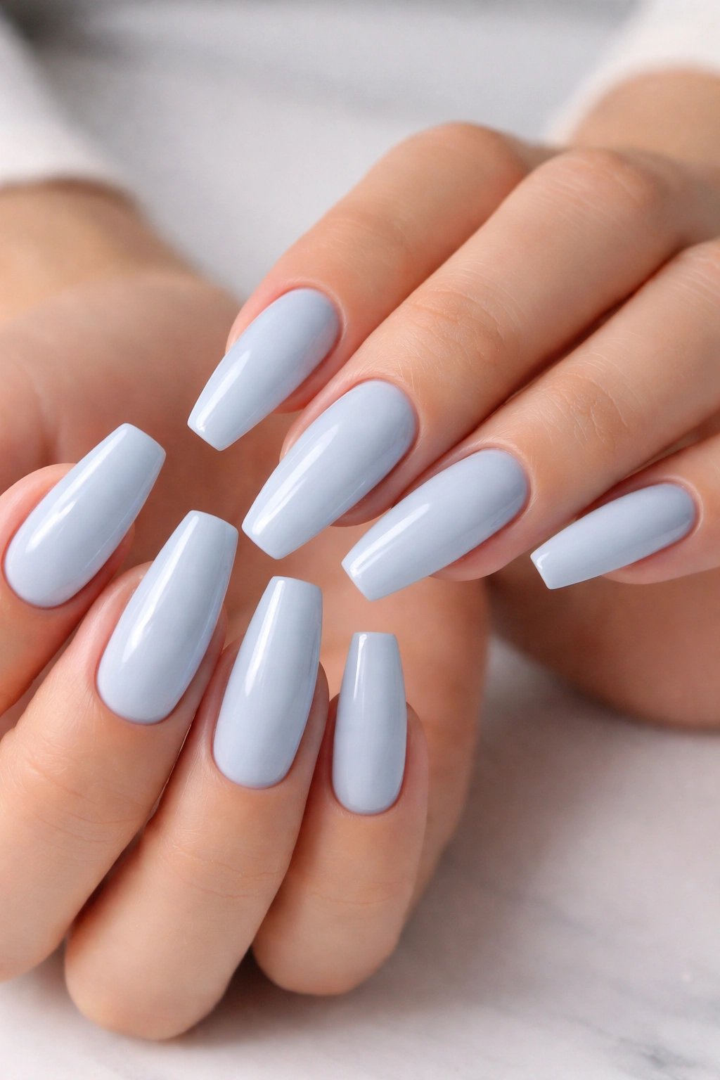 Close-up of hands with pristine baby blue ballerina nails, crisp edges and glossy finish