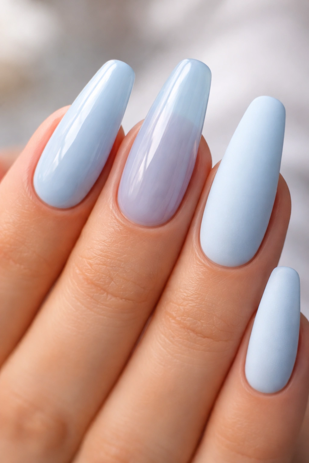 Nails with glossy, jelly, and matte blue finishes on ballerina nails