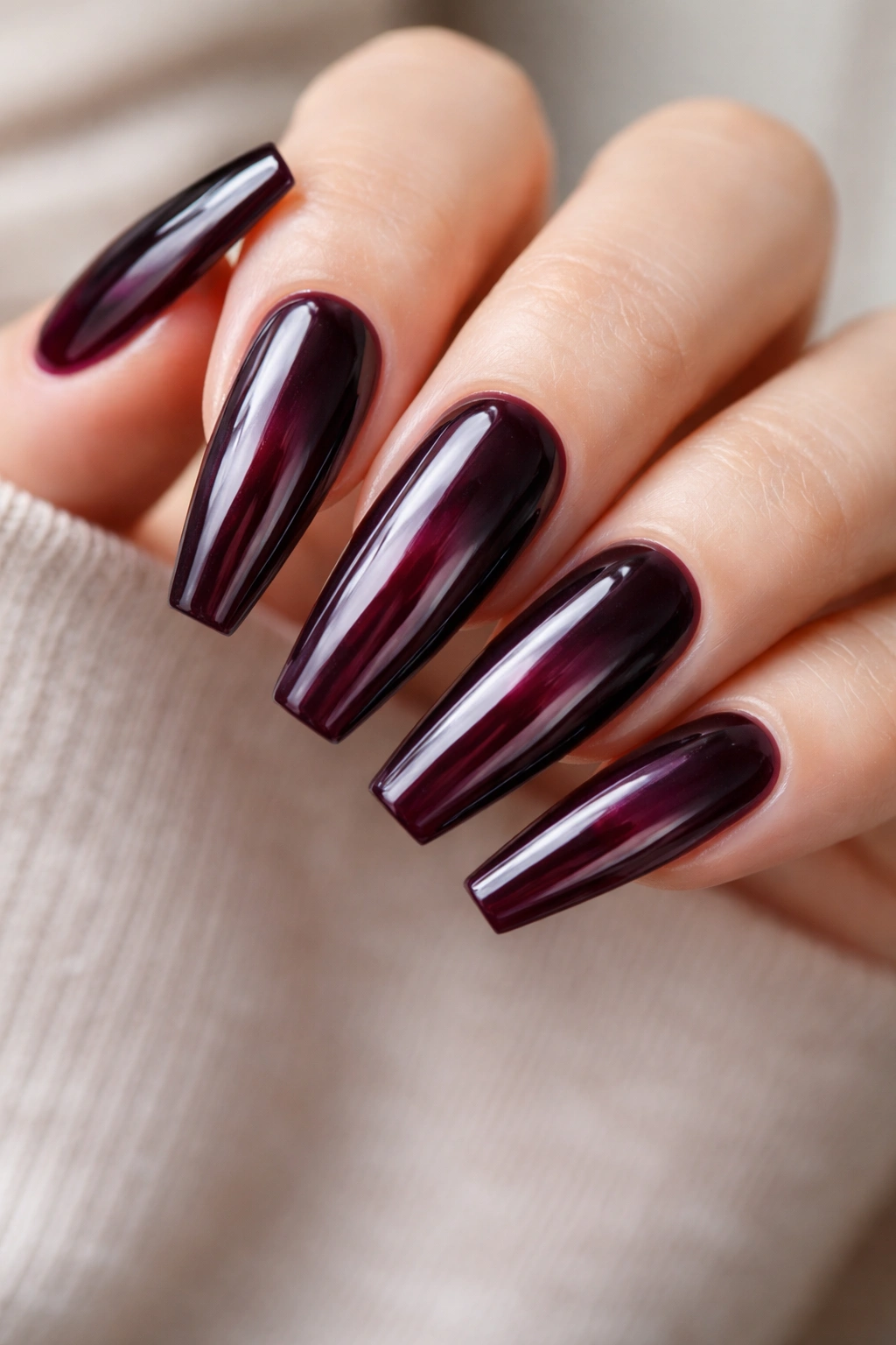Close-up of black cherry-purple glass nails showing translucence and depth