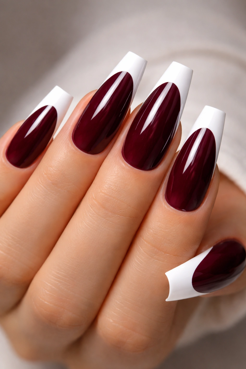 Close-up of coffin nails with burgundy base and white tips
