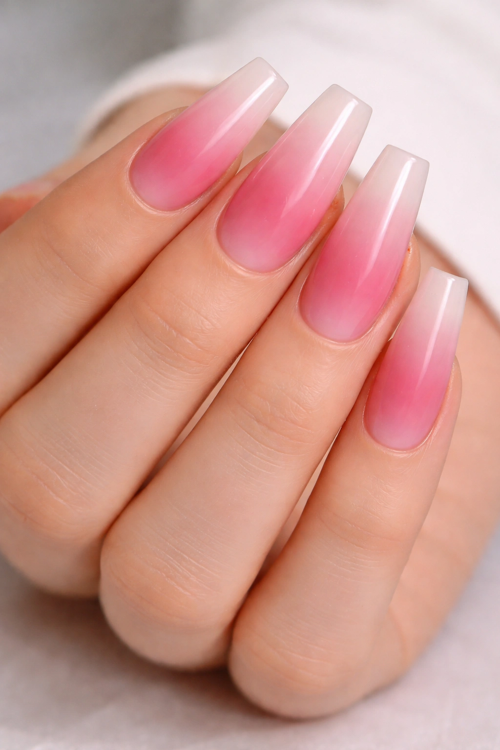 Reverse pink ombre nails with dark base near cuticle fading to pale tip