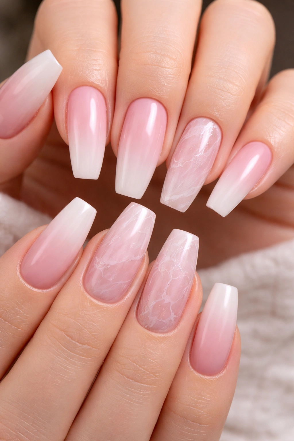 Nails with rose quartz marble accents on two nails among pink ombre nails