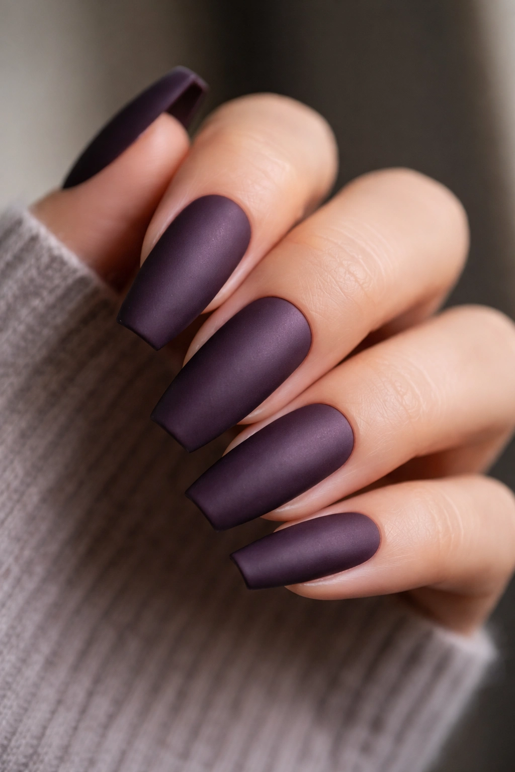 Close-up of smoky plum matte nails with velvet finish