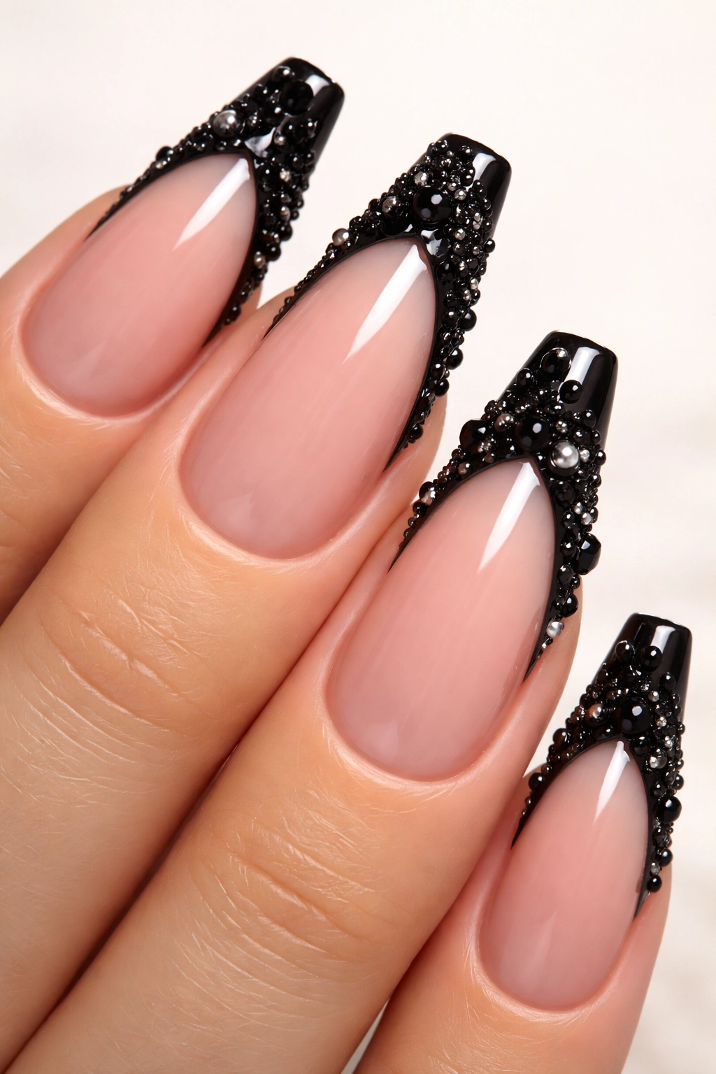 Close-up of coffin nails with black tips and 3D embellishments