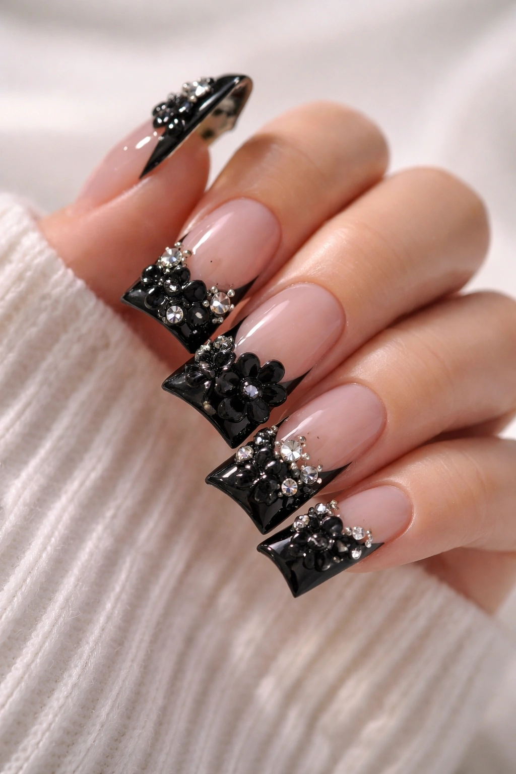 Close-up of duck-shaped nails with 3D embellishments on the black tip