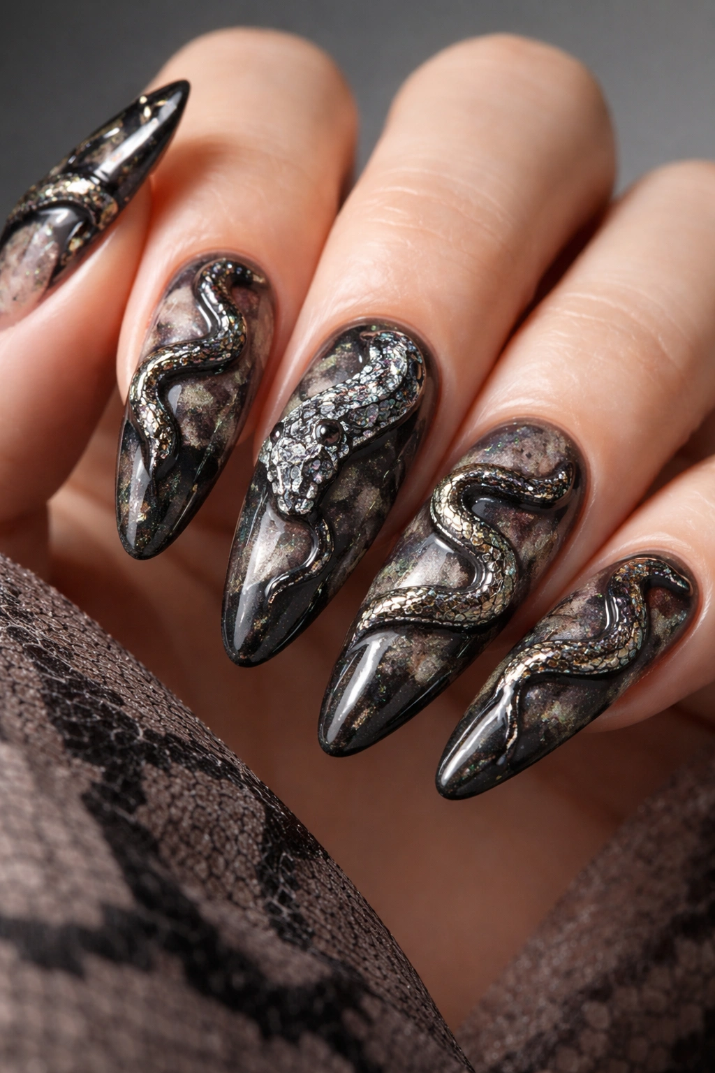 Nails featuring a 3D sculpted snake embellishment on a colored base.