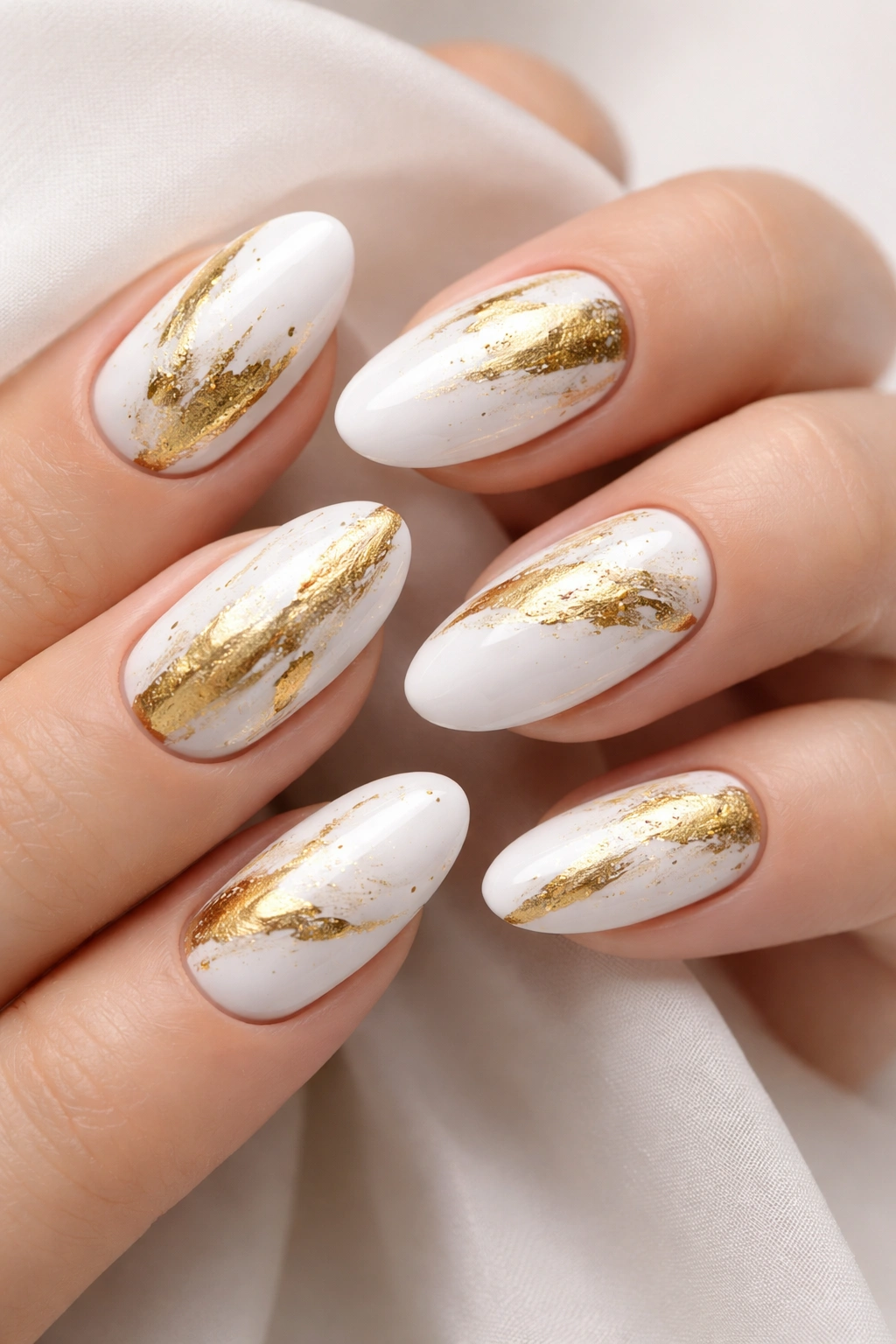 Nails with abstract gold brushstroke details on white base