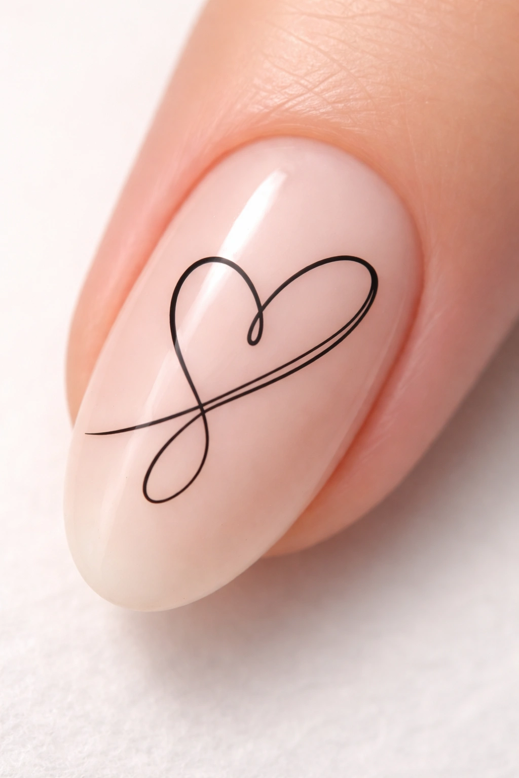 Nail with abstract continuous-line heart drawn on nude nail