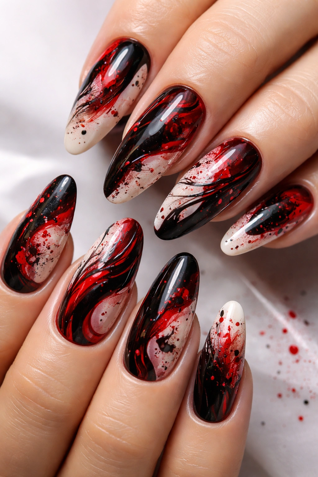Close-up of nails with red and black abstract splatter nail art
