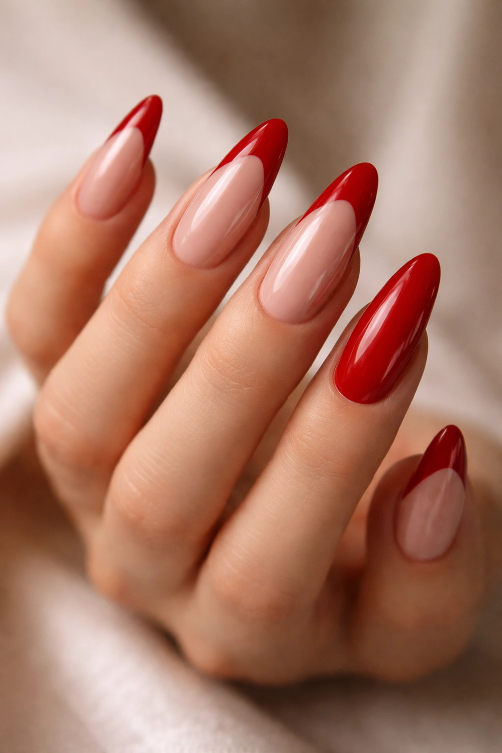 Hand with long almond nails showing nine red French tips and one solid red accent nail