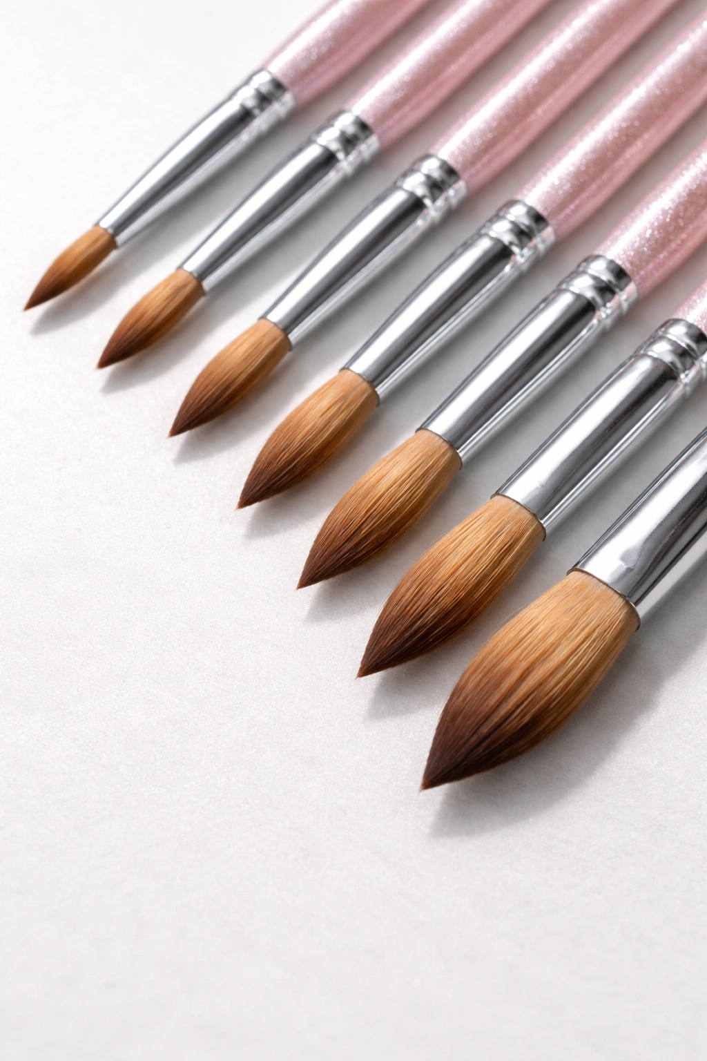 Row of acrylic brushes showing different bristle widths on a light counter