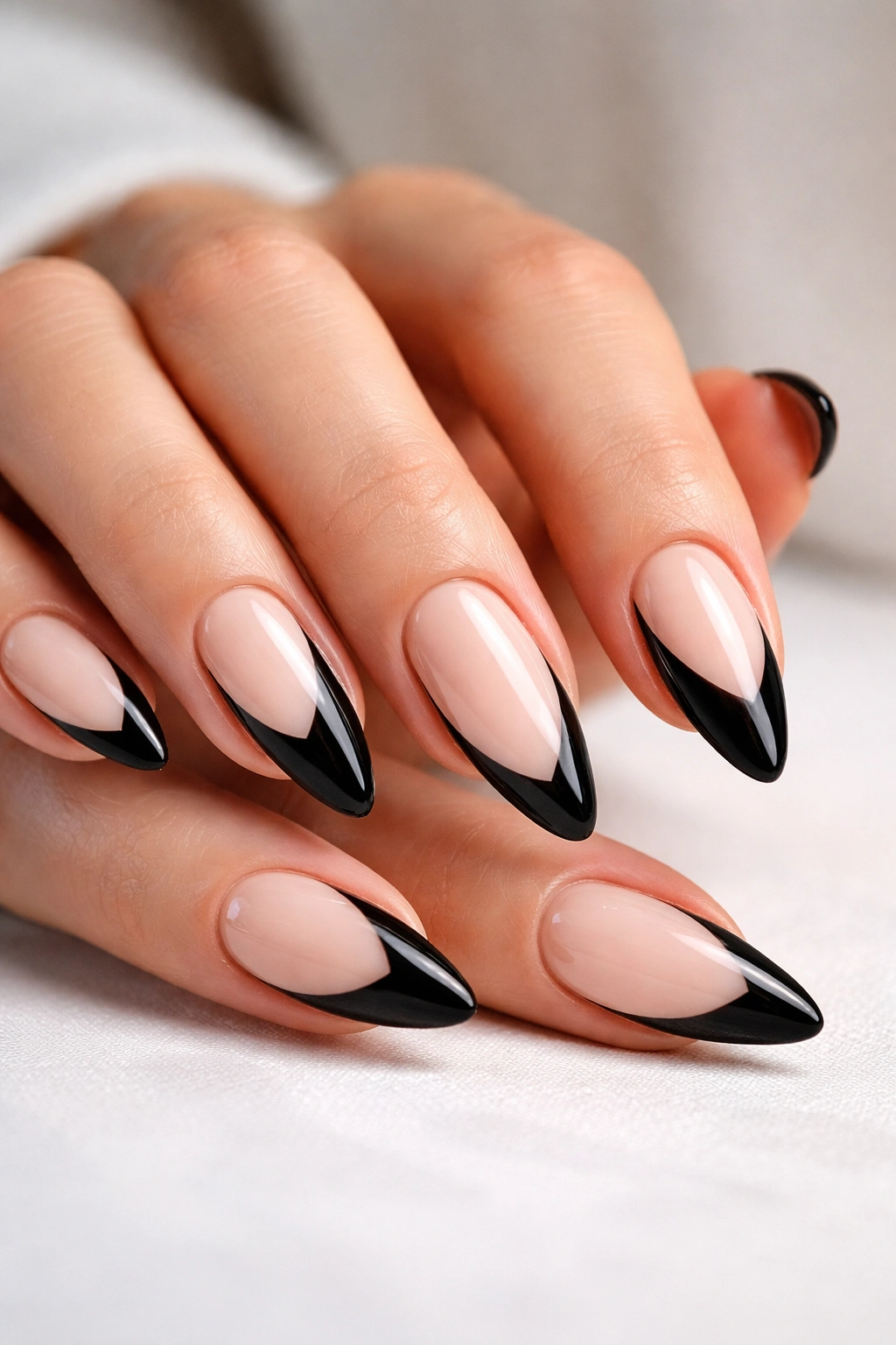 Close-up of almond nails with black and nude contrast and crisp lines