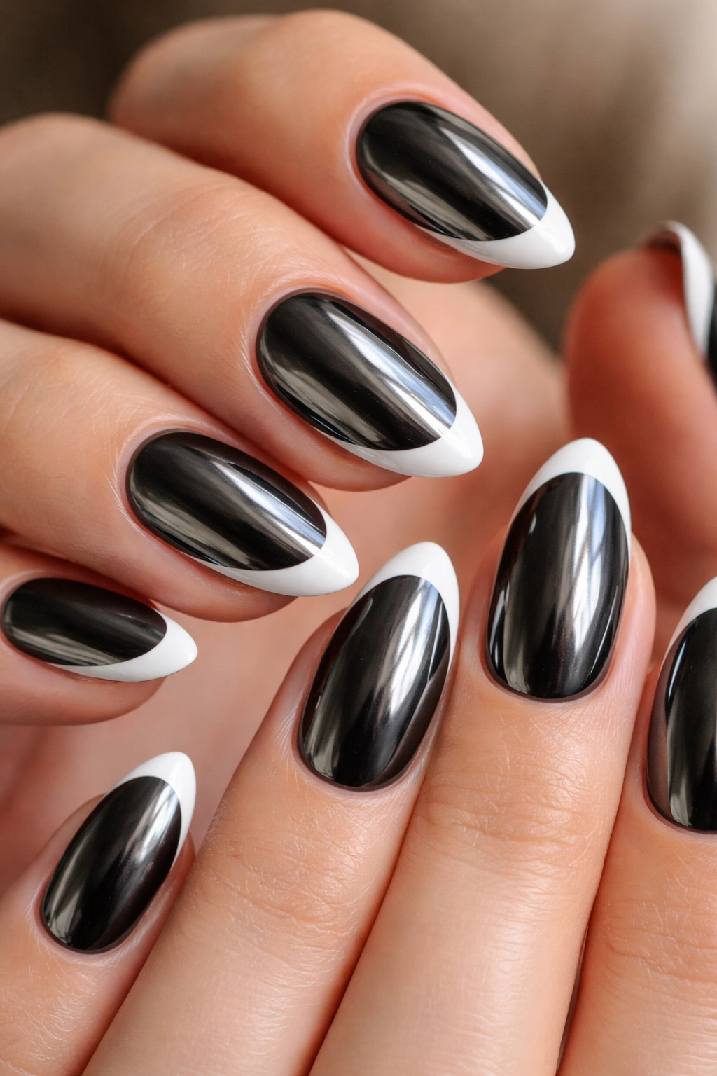 Close-up of chrome black almond nails with white tips reflecting light