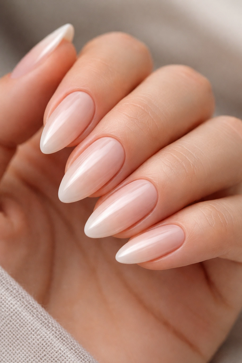 Close-up of almond nails with clean cuticle lines on a hand