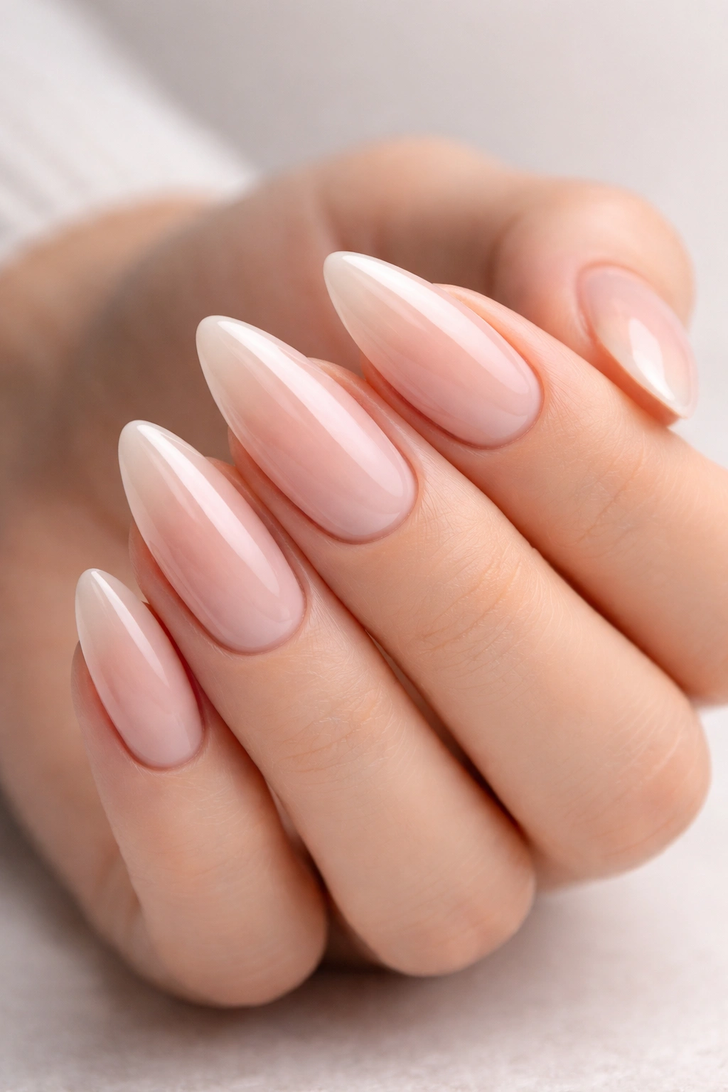 Close-up of a hand with almond-shaped nails showcasing tapered, elongated tips.