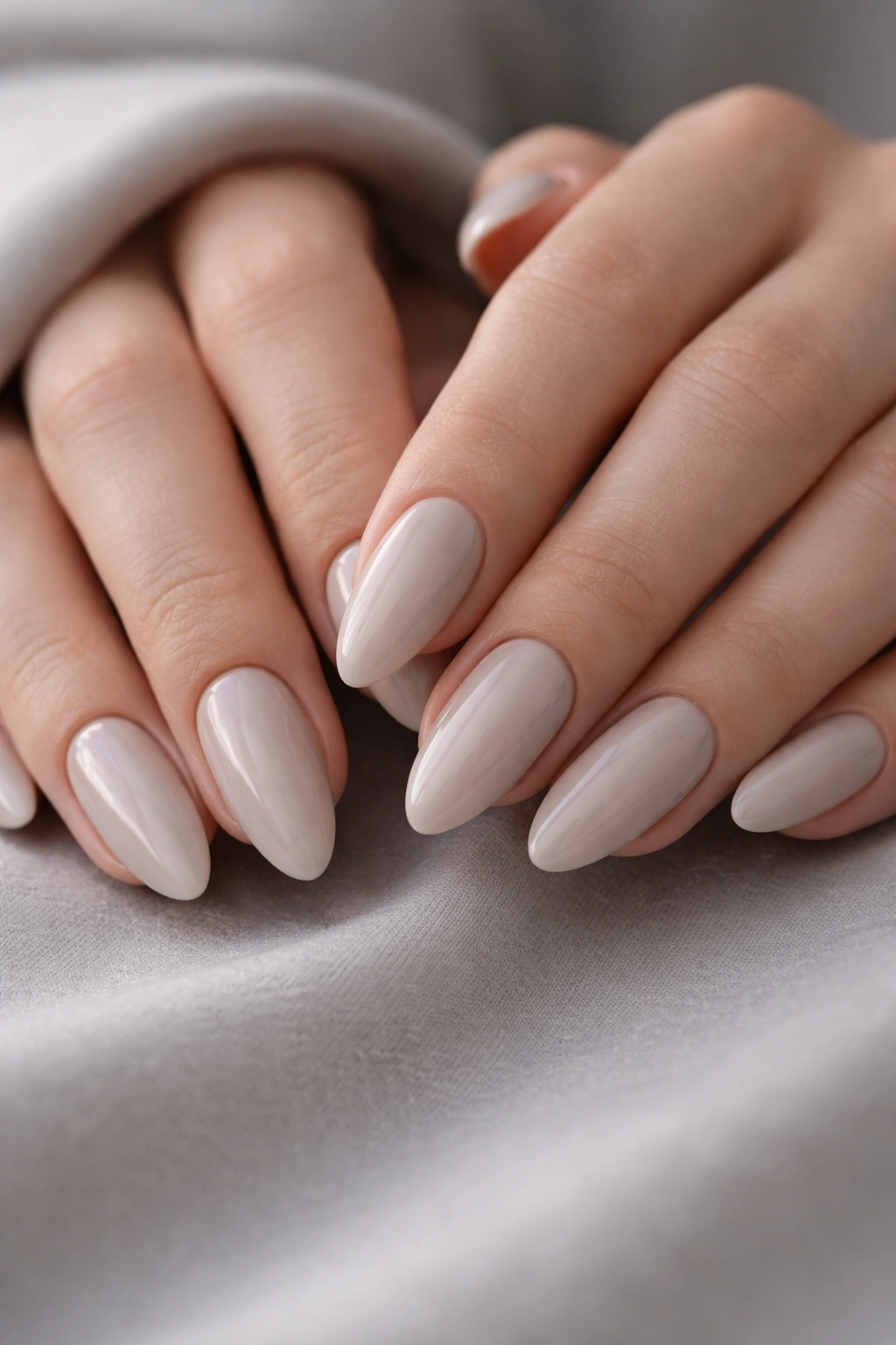 Almond nails in cool beige with gray undertone and glossy finish