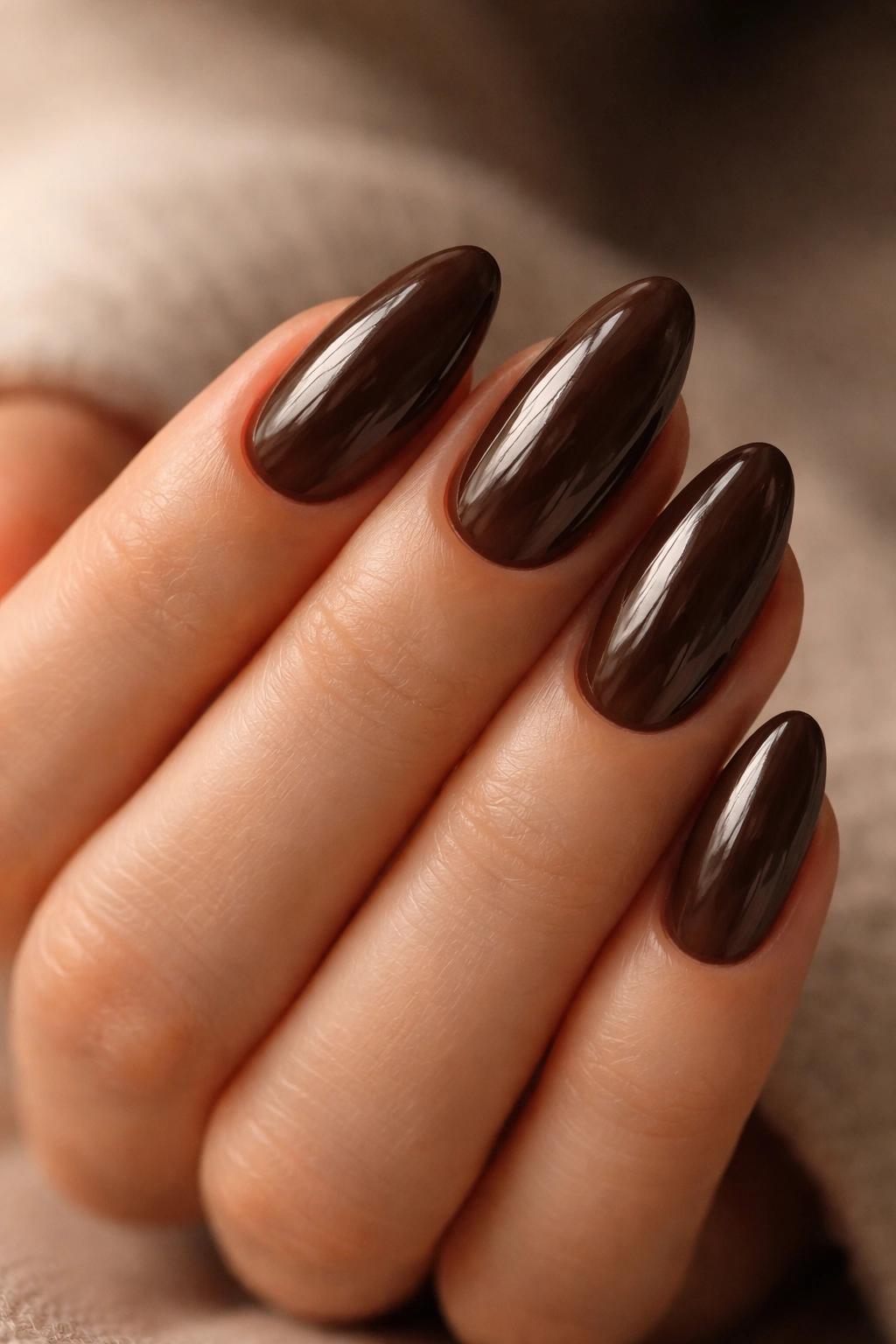 Close-up of short almond nails in espresso tint with glossy finish