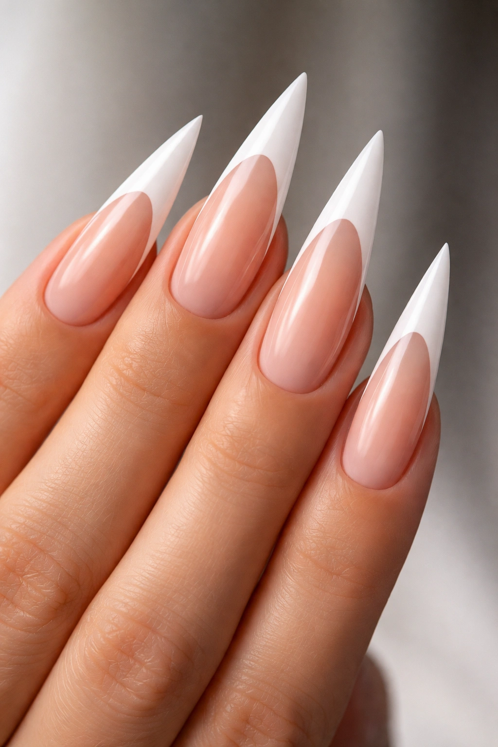 Close-up of ultra-long almond nails with sharp white tips and precise lines