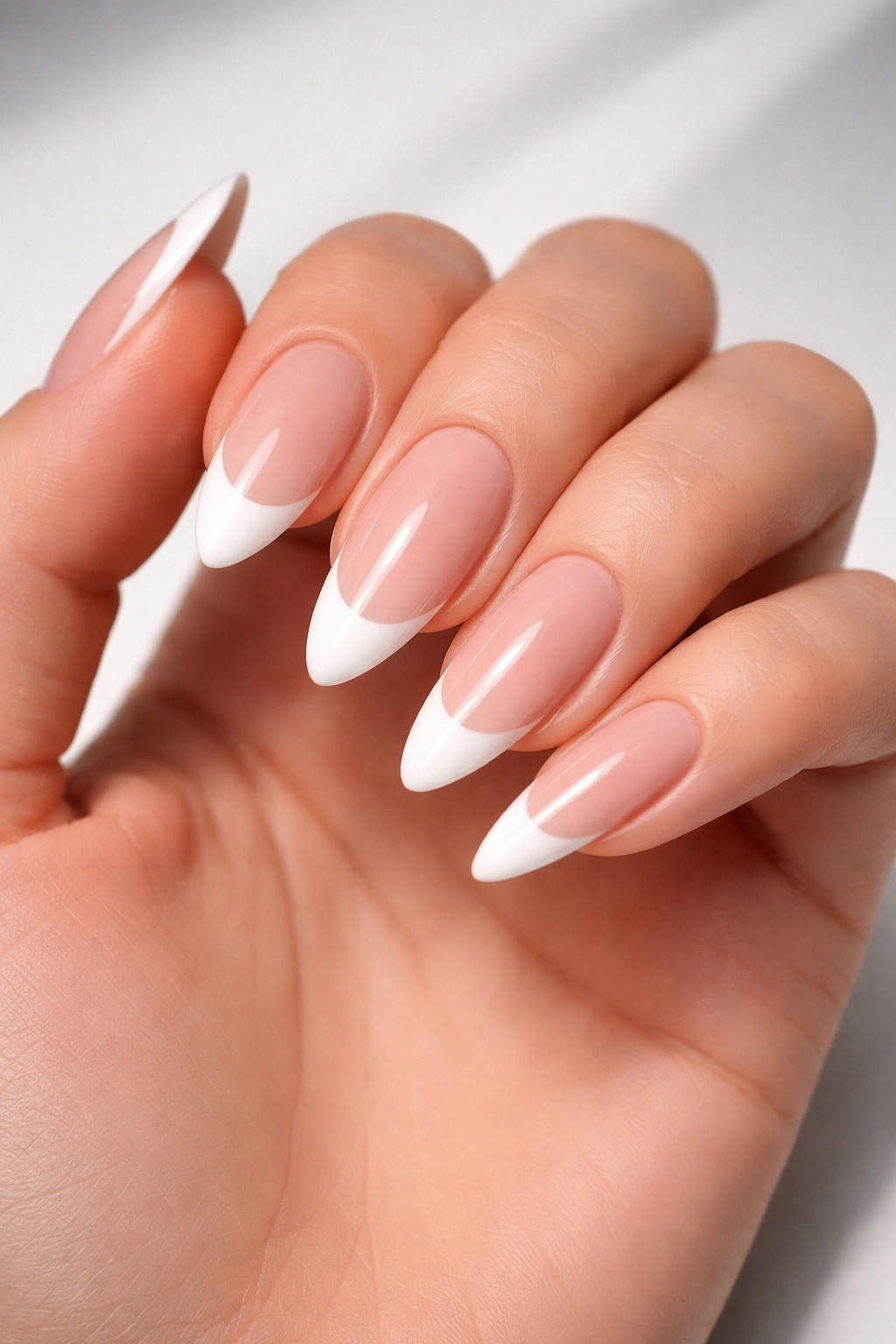 Almond nails with classic white French tips on nude base