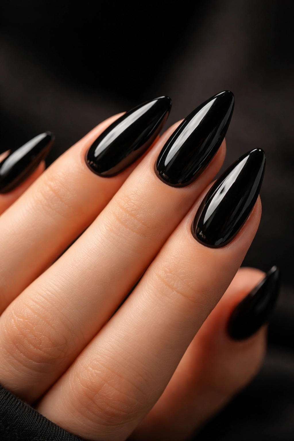 Close-up of glossy black almond nails with high shine