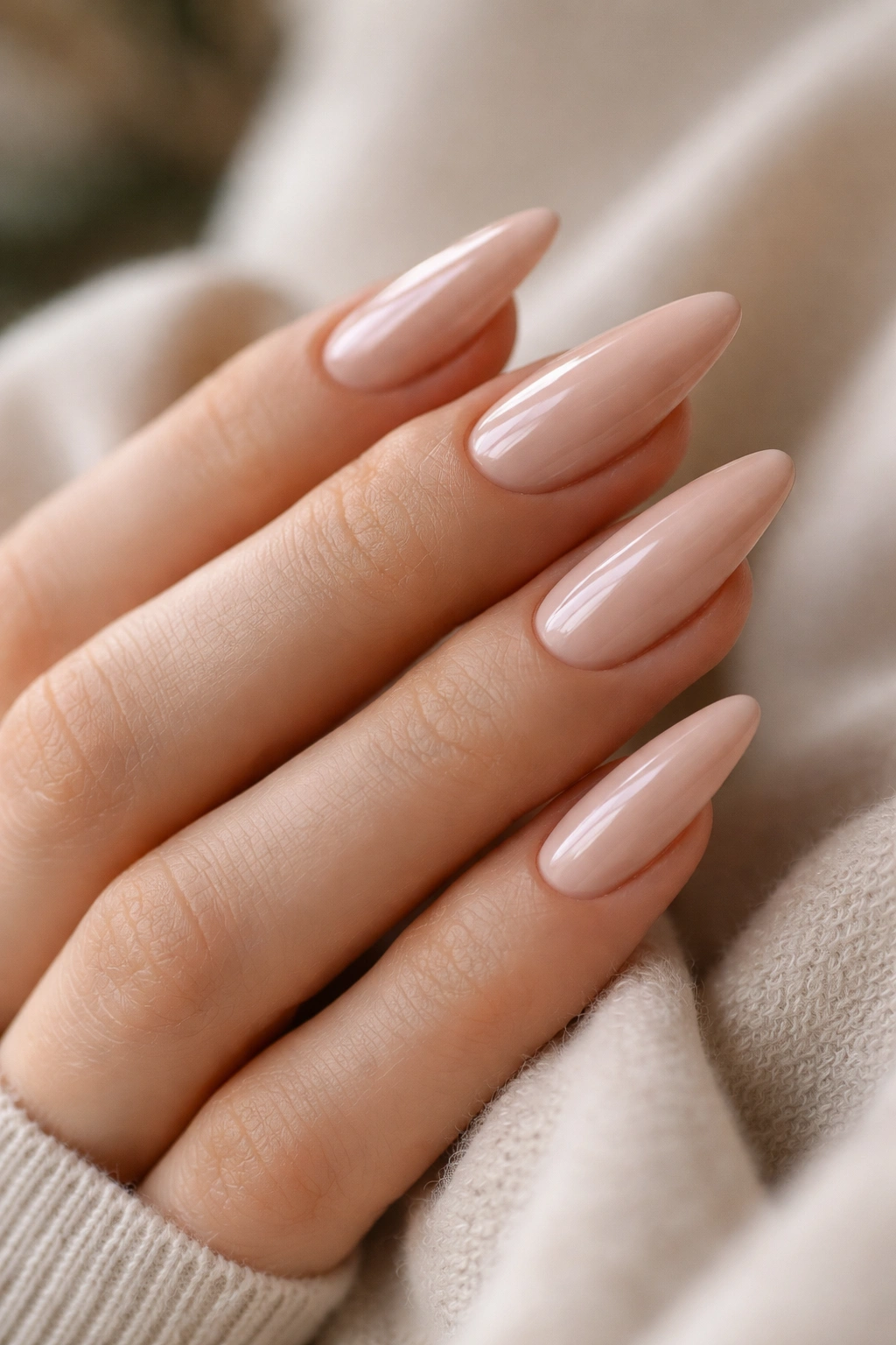Close-up of medium-long almond nails with a glossy finish on a hand