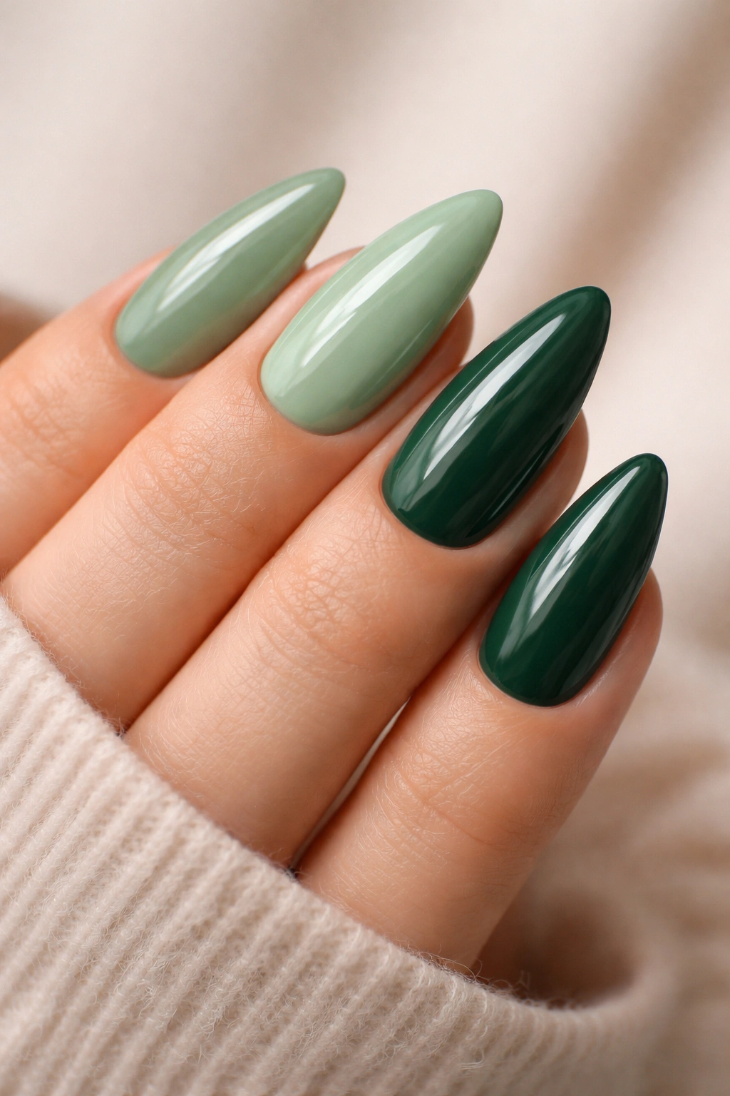 Close-up of almond nails in green shades with glossy finish
