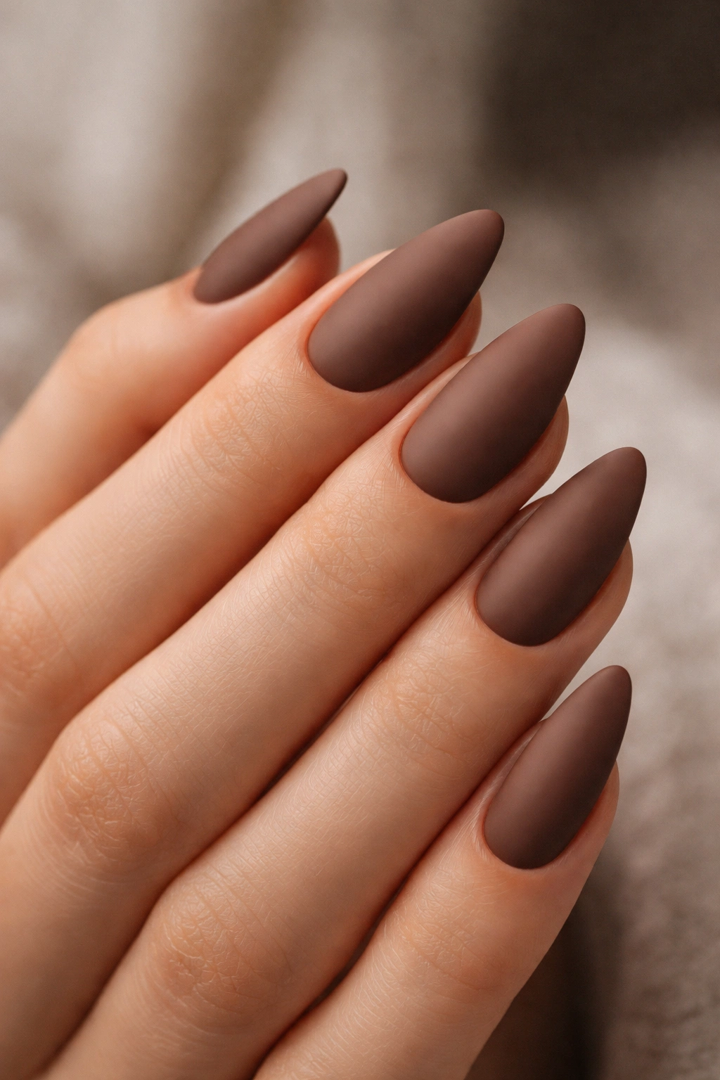 Close-up of matte cocoa almond nails with a velvety finish