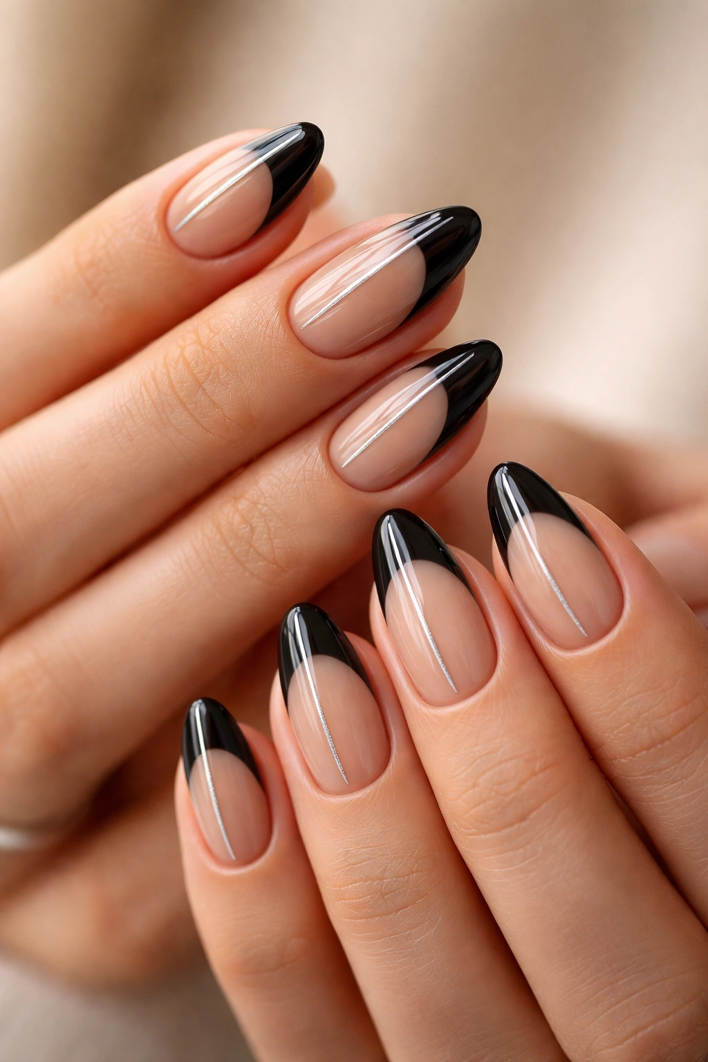 Almond nails with black base, white tips, and a thin metallic accent line