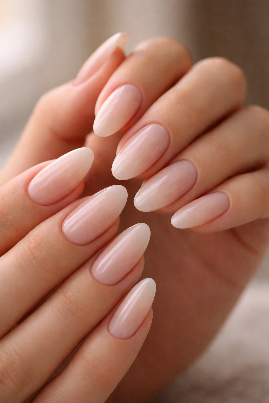 Close-up of almond nails with sheer milky finish on clean hands, glossy and translucent.