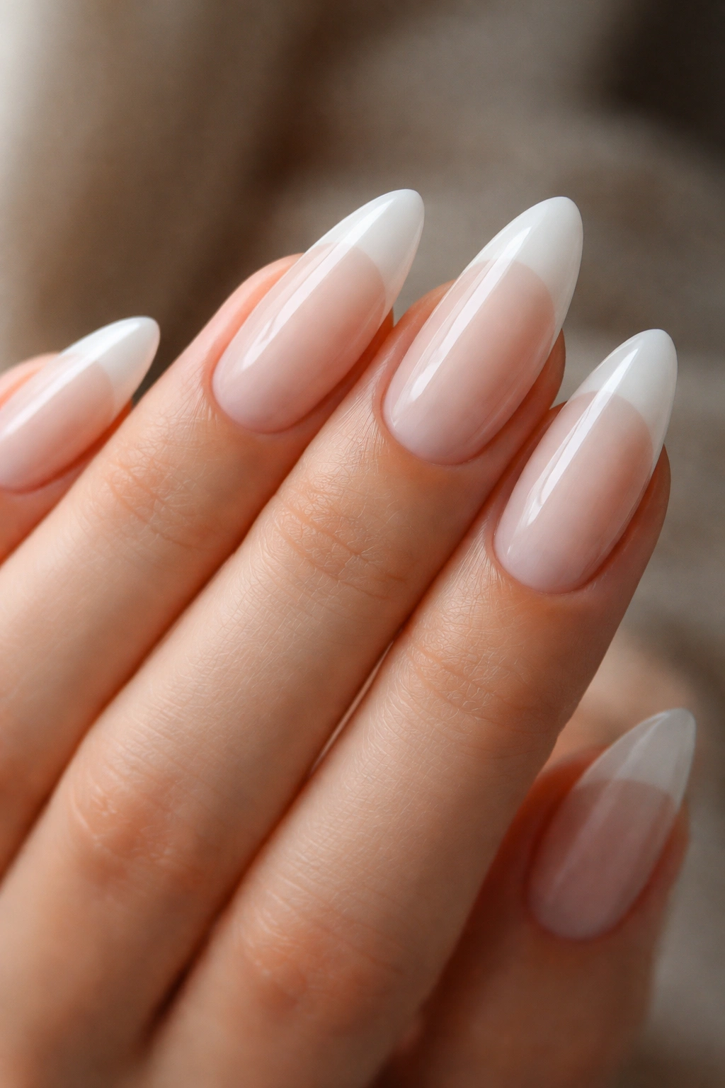 Close-up of almond nails with milky translucent tips blending into a sheer base