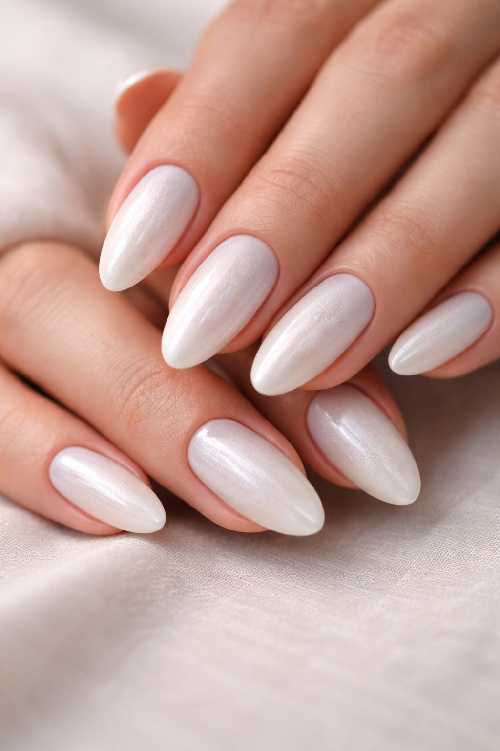 Close-up of almond nails in pearl white with soft shimmer
