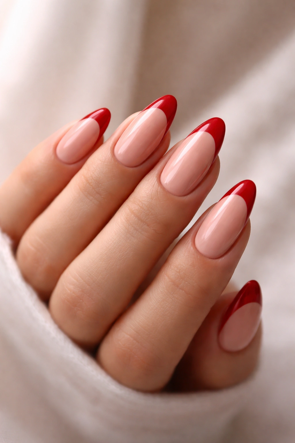 Almond-shaped nails with red French tips and graceful arc