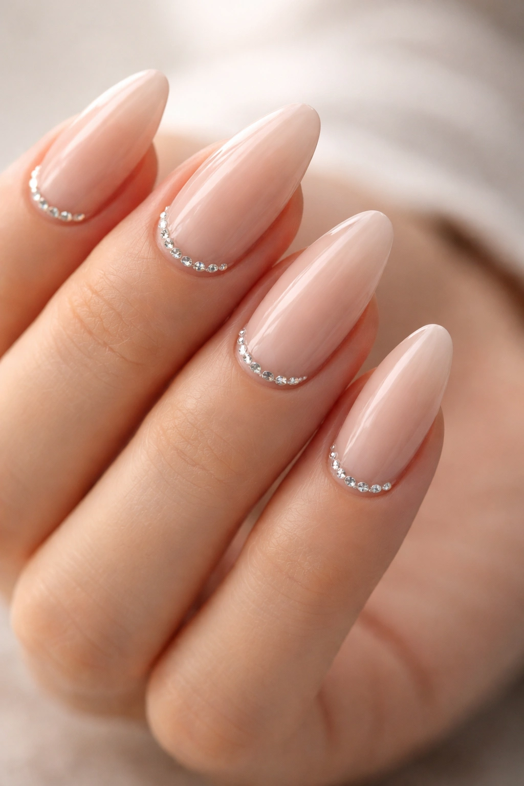 Almond nails with rhinestone cuticles on a pale pink base