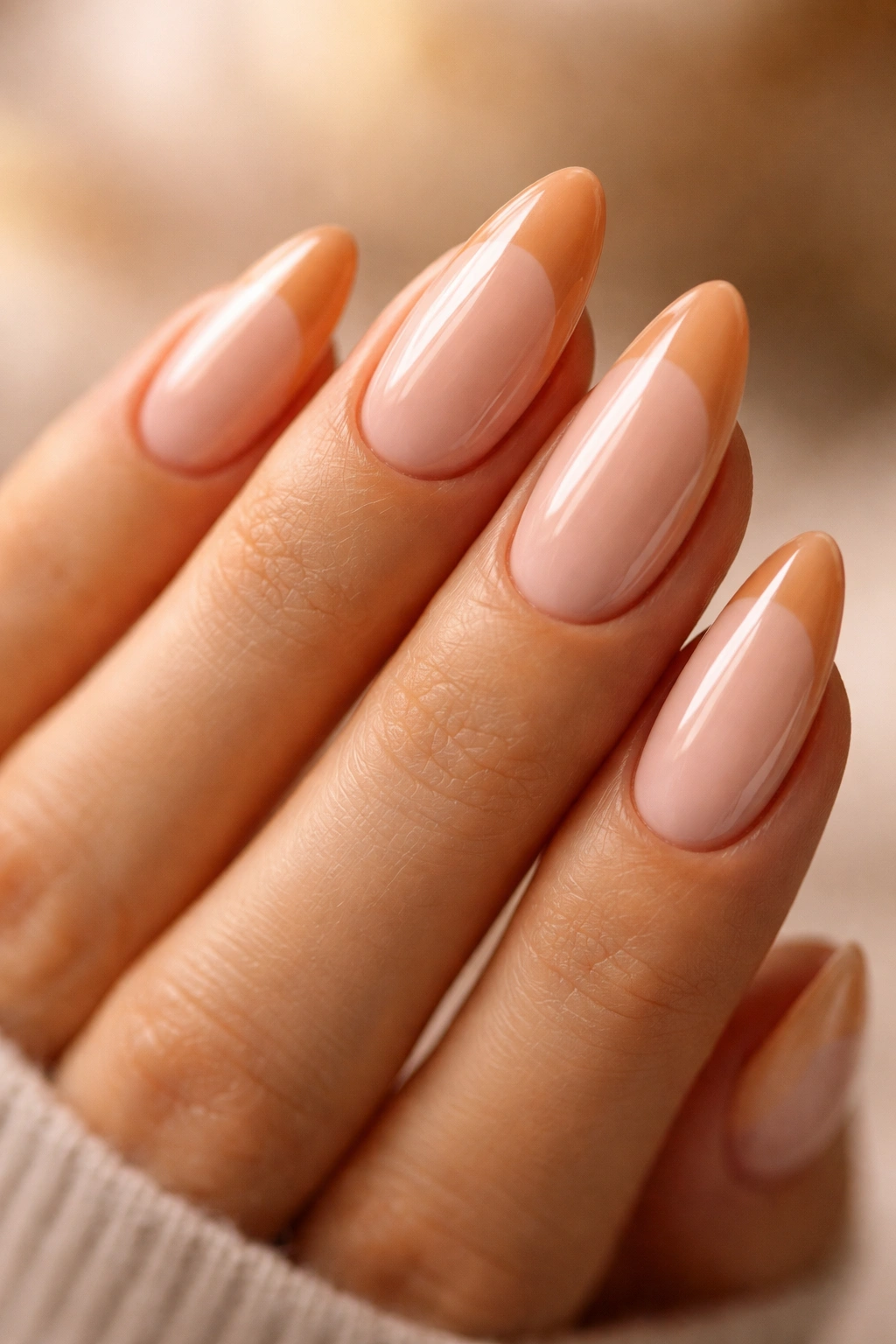 Almond nails with warm French tips highlighting curved smile line.
