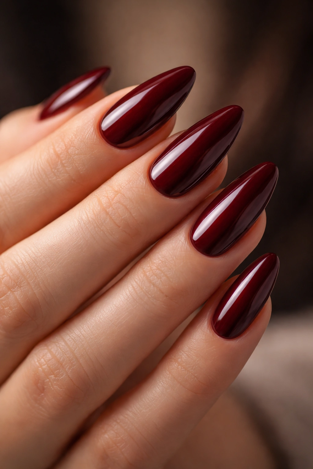 Close-up of deep wine red almond nails with rich color