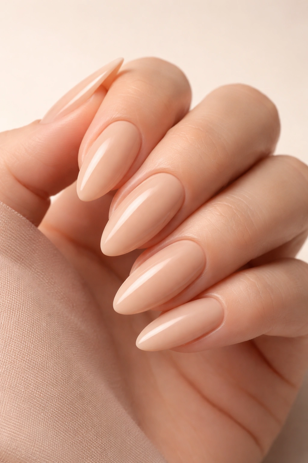 Almond-shaped nude beige nails on hand