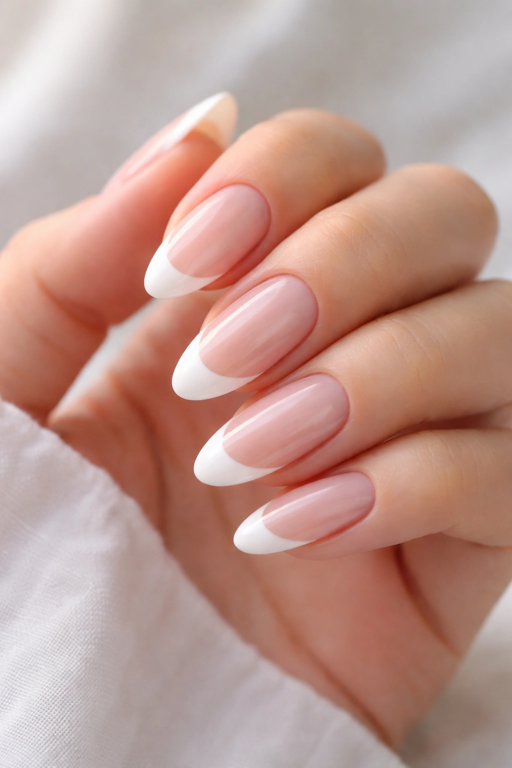 Soft almond shape adaptation on long round nails with crisp white tips.