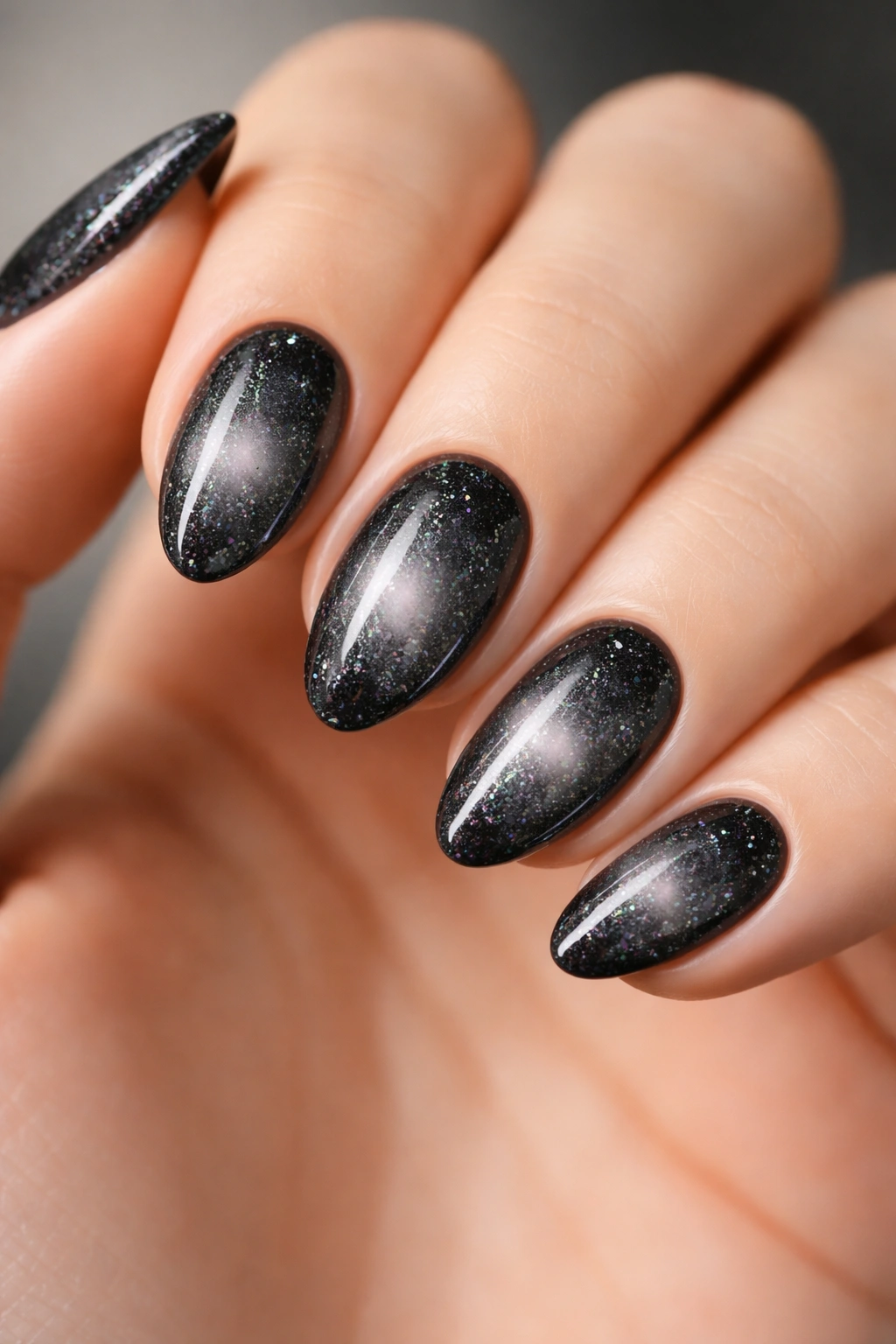 Short almond nails with black glitter and soft central glow aura