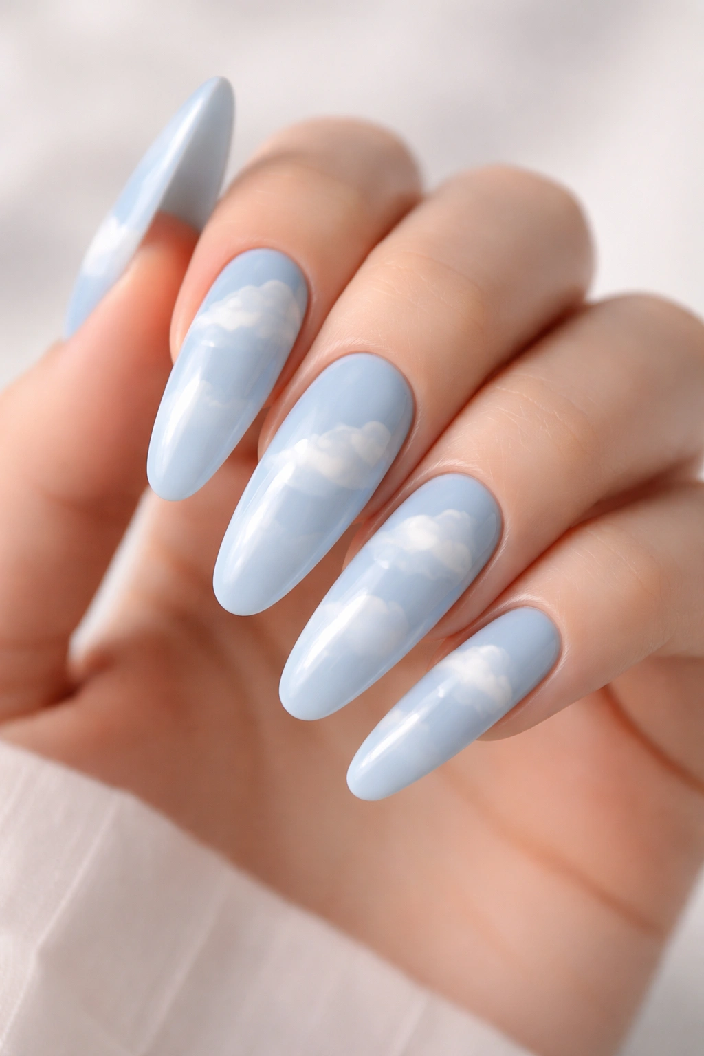 Close up of baby blue nails with subtle cloud designs