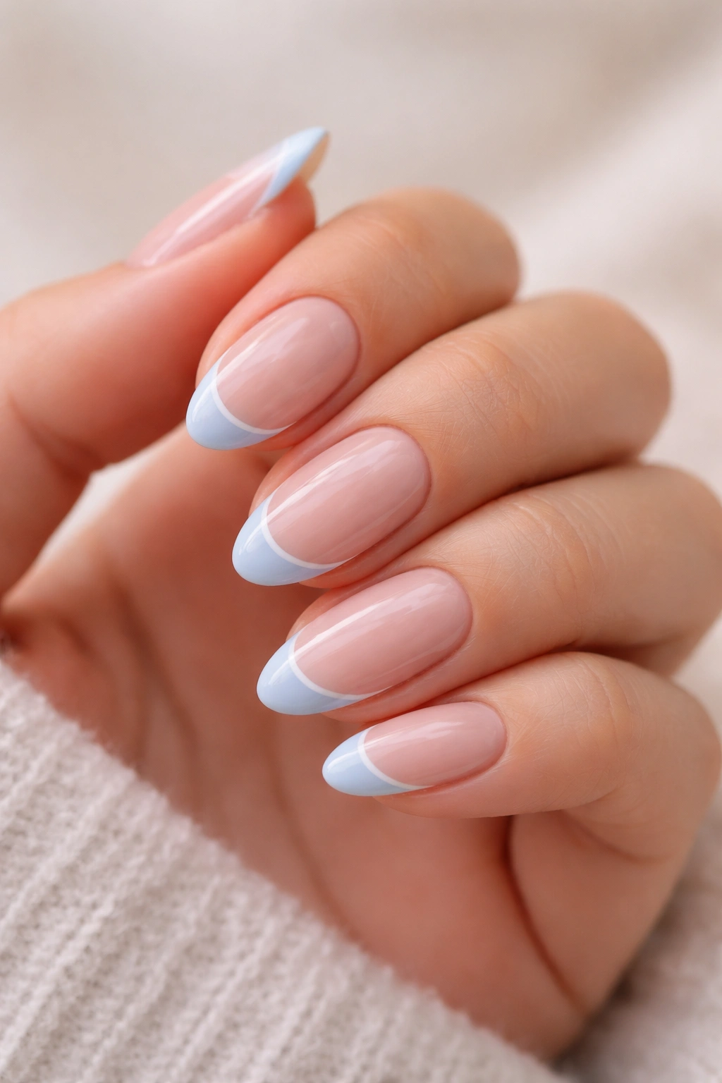 Baby blue nail tips with a fine white outline on short almond nails