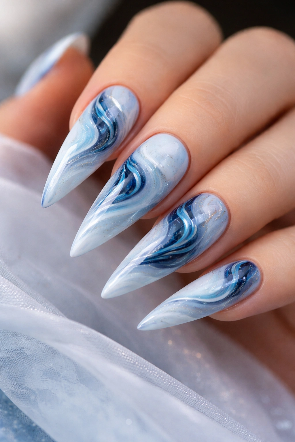 Close-up of baby blue marble design stiletto nails
