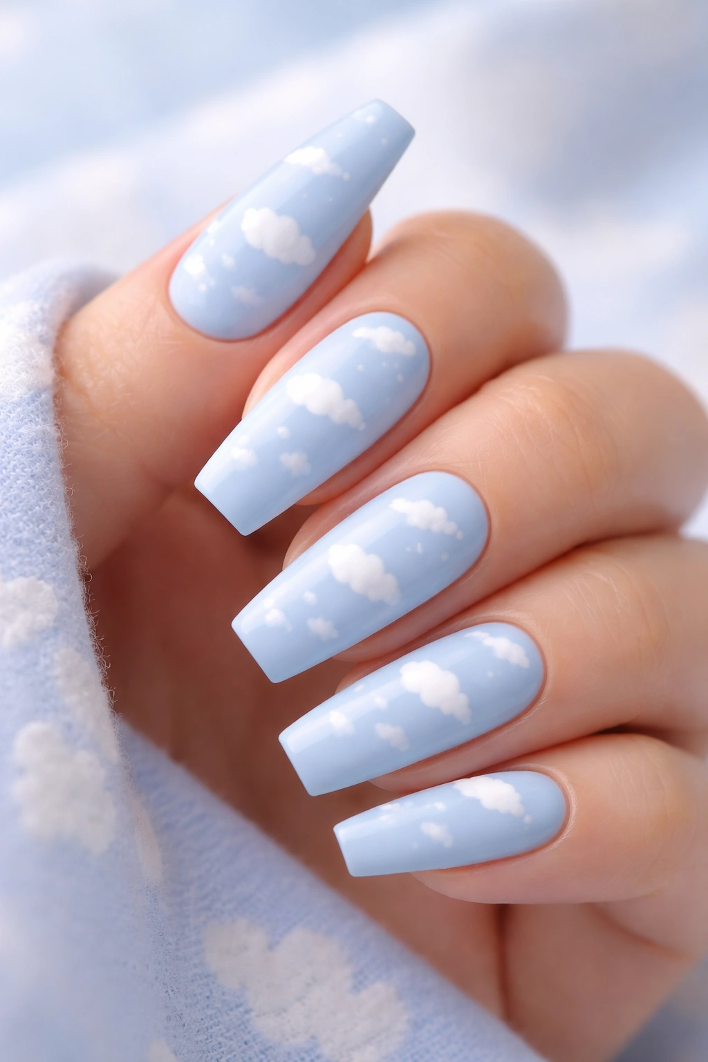 Close-up of baby blue coffin nails with tiny white clouds