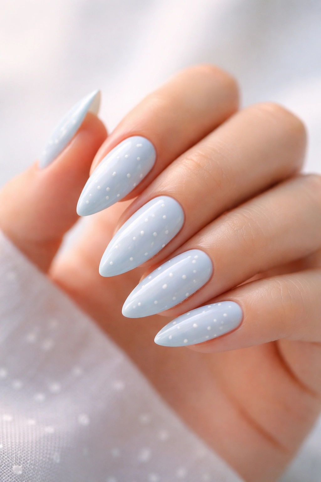 Close-up of baby blue nails with small white dots