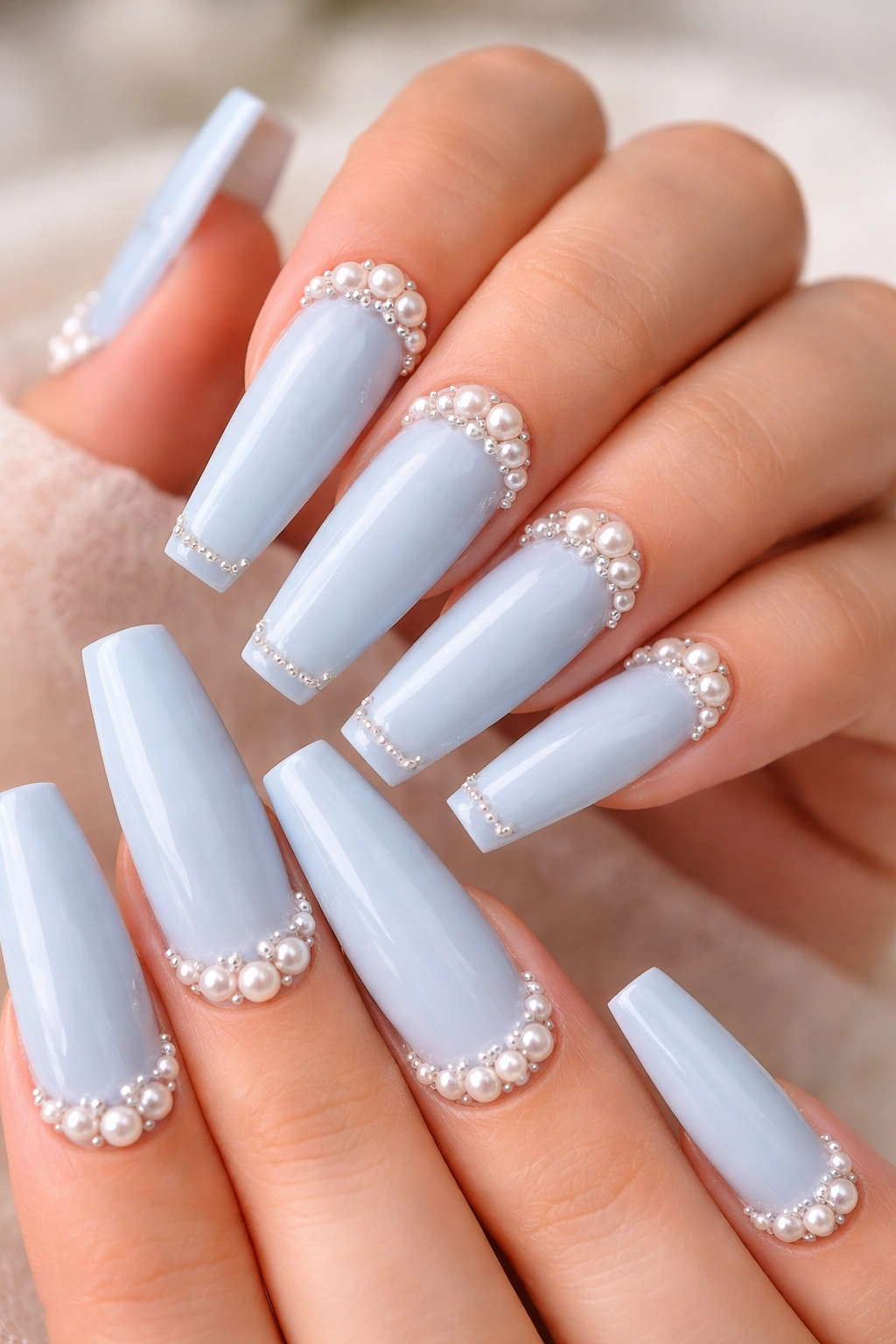Close-up of baby blue coffin nails with pearl accents