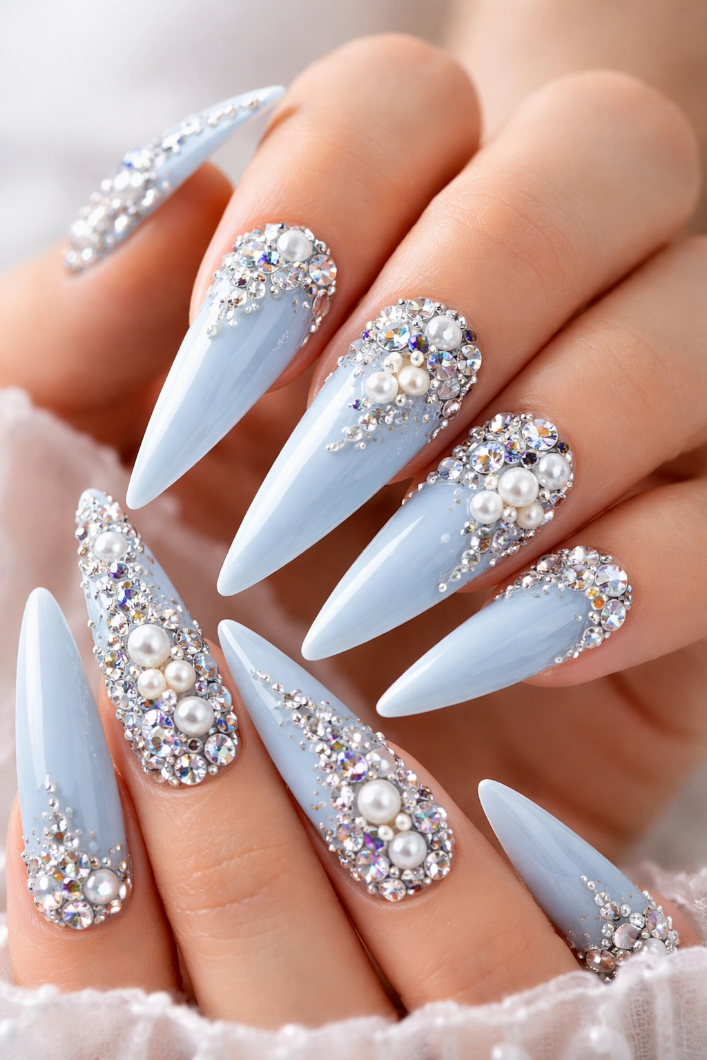 Baby blue stiletto nails with rhinestones and 3D embellishments
