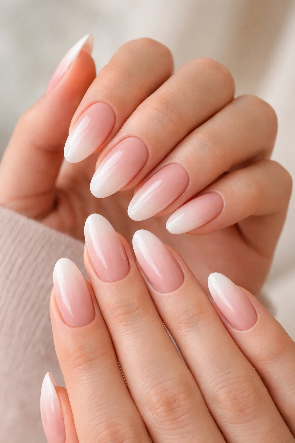 Close-up of hands with pink-to-white baby boomer fade tapered oval nails